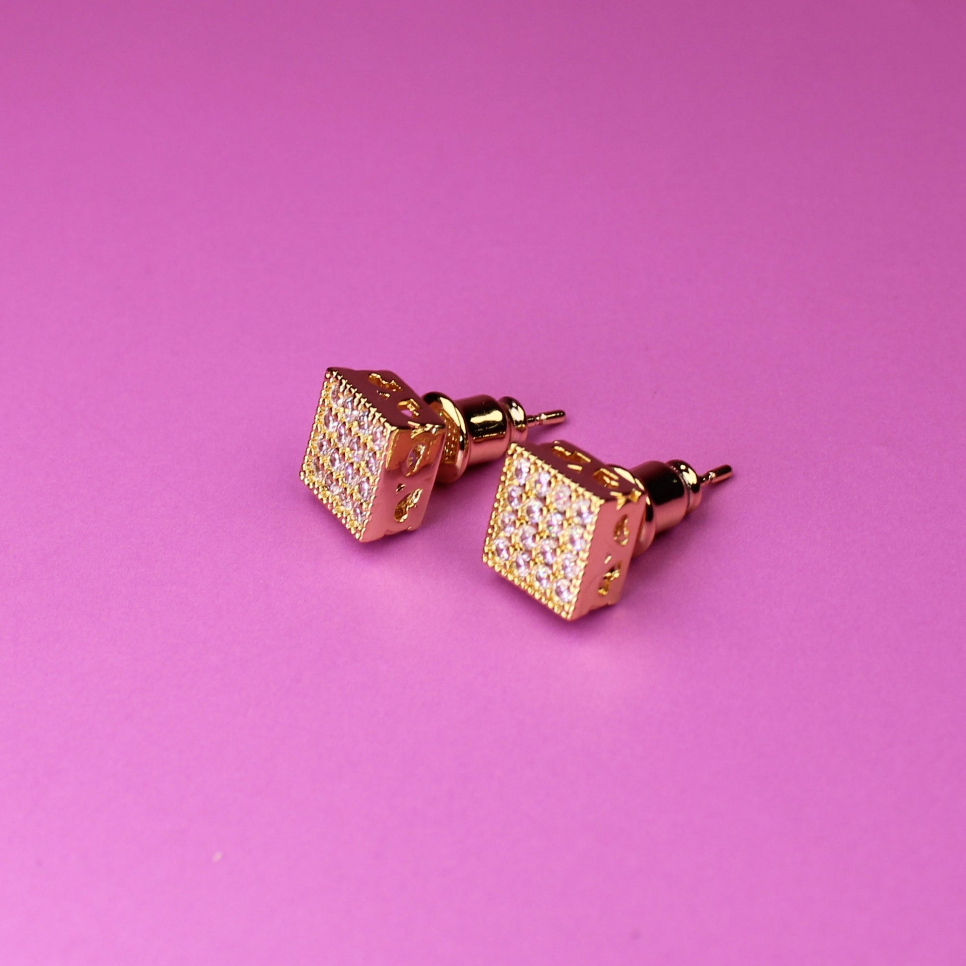 Rose gold cufflinks on a pink background