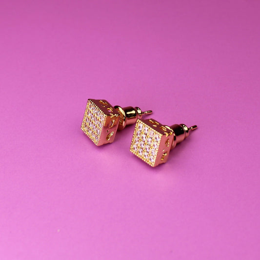 Rose gold cufflinks on a pink background