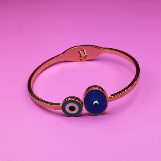 Copper bracelet with blue evil eye charm on a pink background