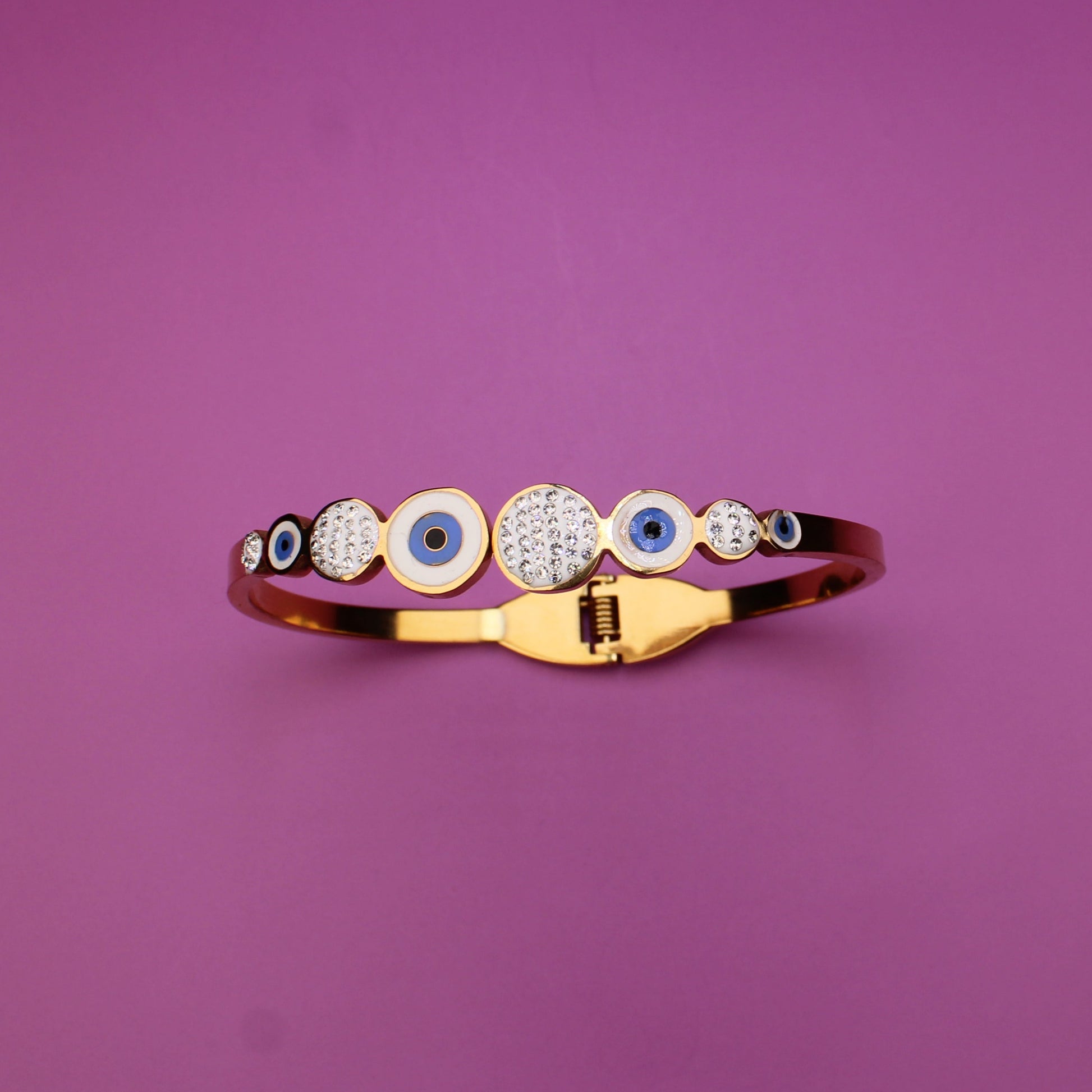 Gold ring with embedded stones on a purple background