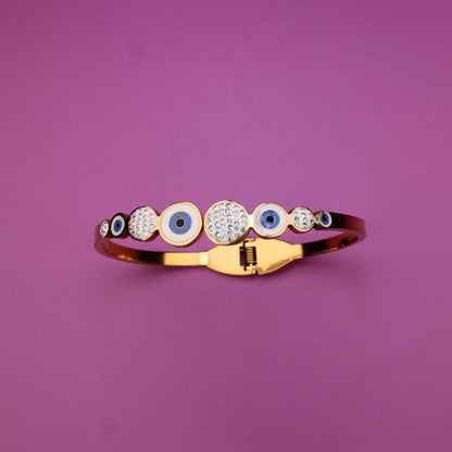 Gold ring with embedded stones on a purple background
