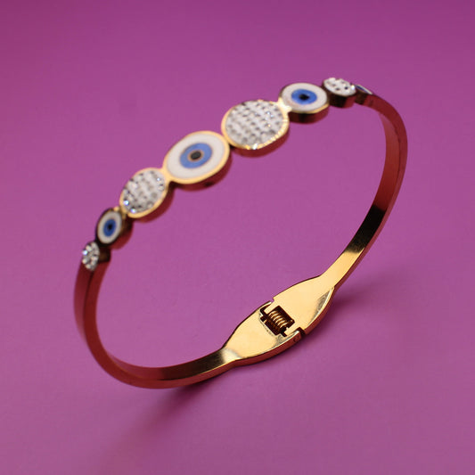 Gold bracelet with gemstones on a purple background