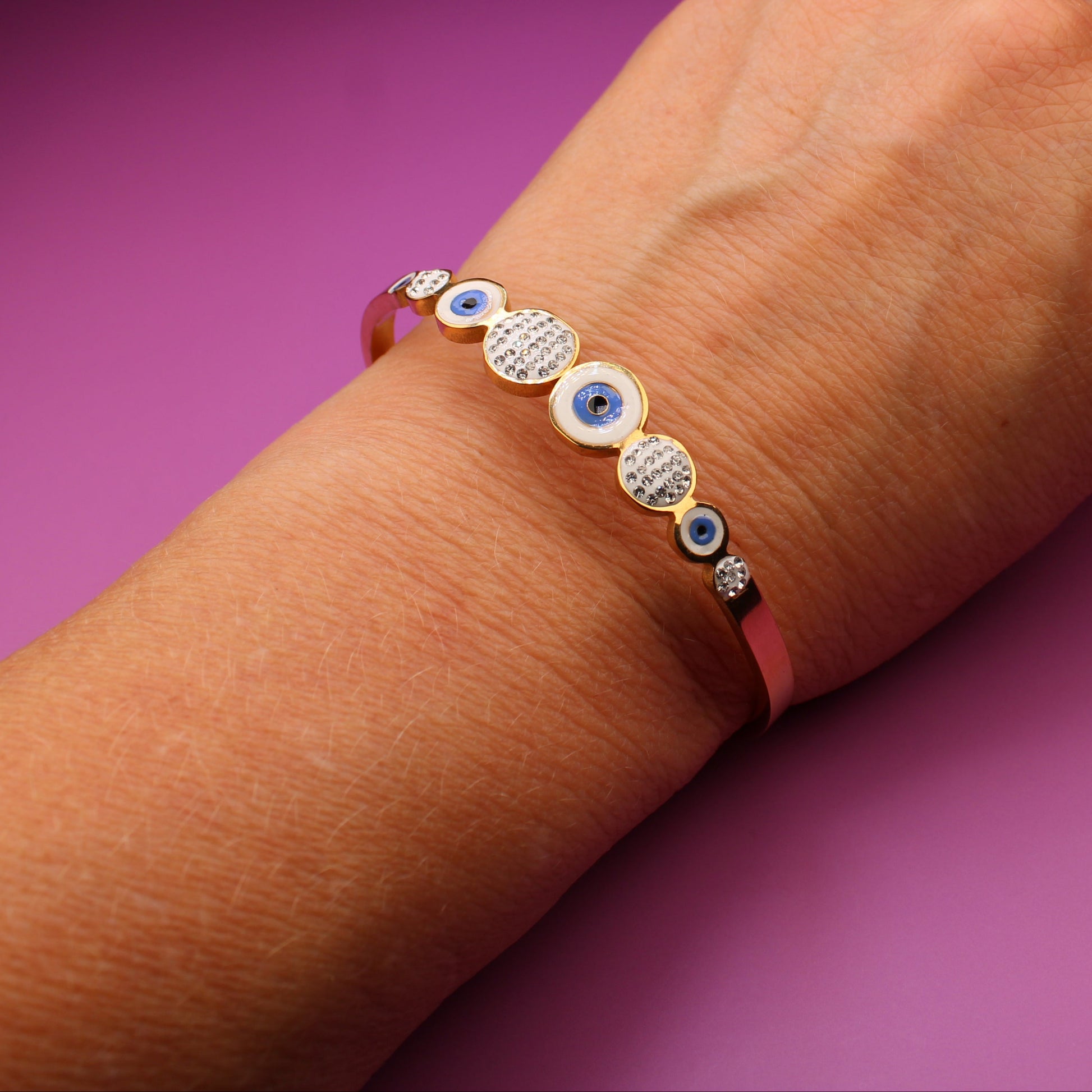 Hand wearing a bracelet with purple background