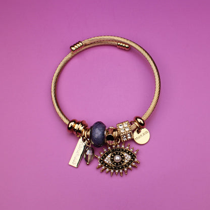 Gold bracelet with charms on a purple background