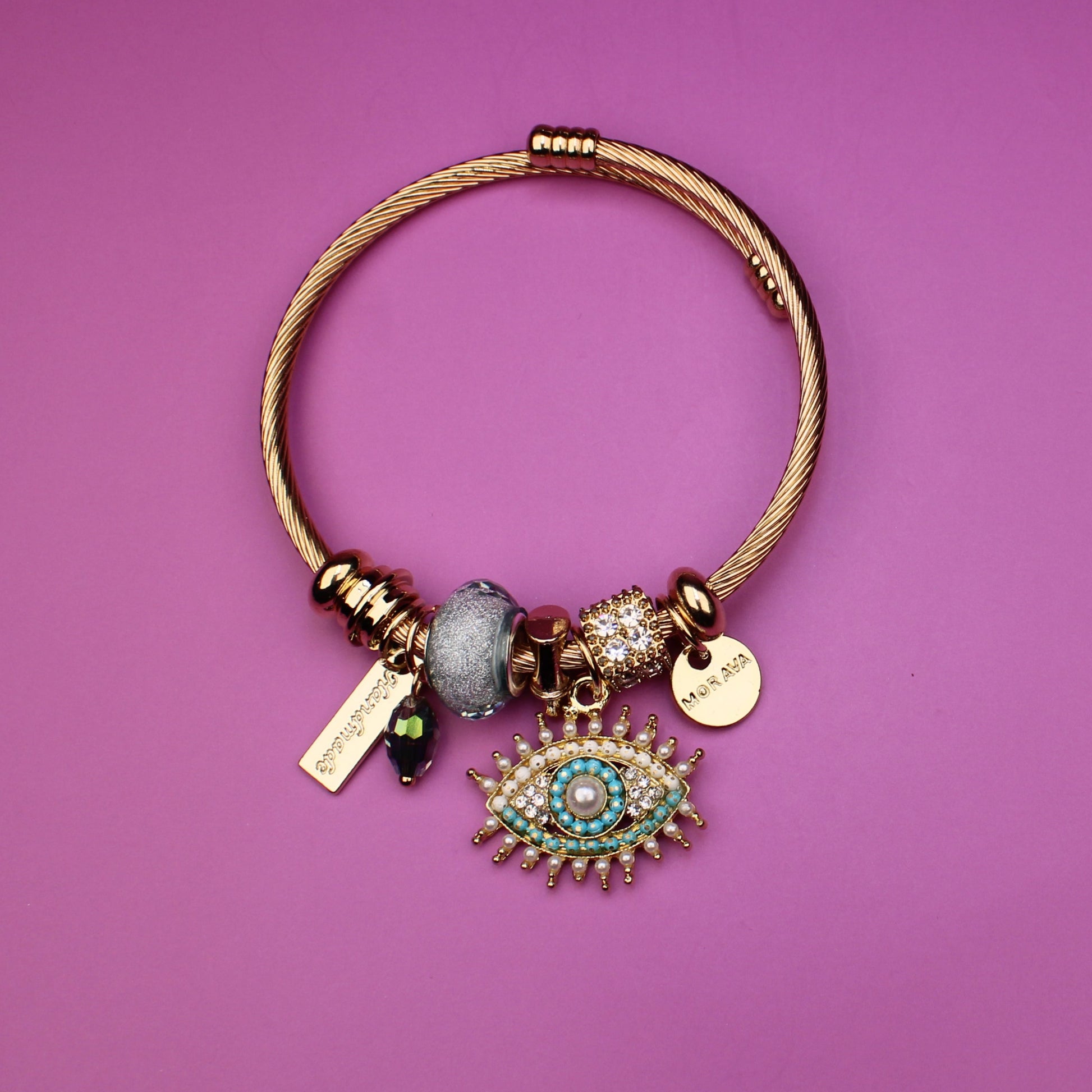 Gold bracelet with charms on a purple background