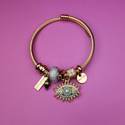 Gold bracelet with charms on a purple background