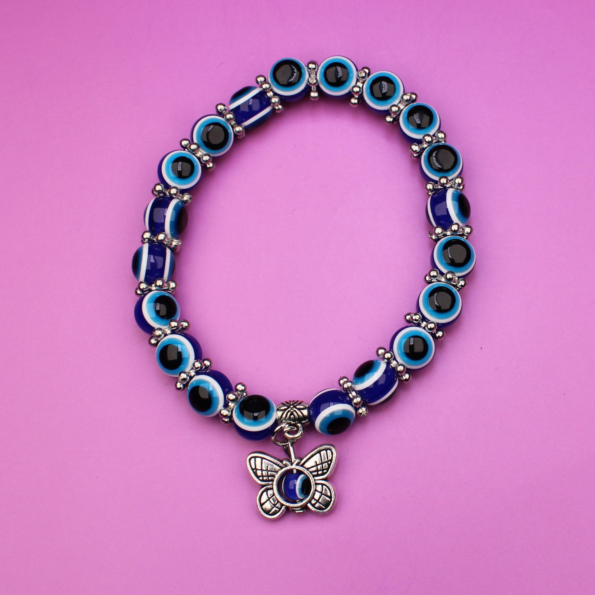 Bracelet with blue and green beads on a pink background