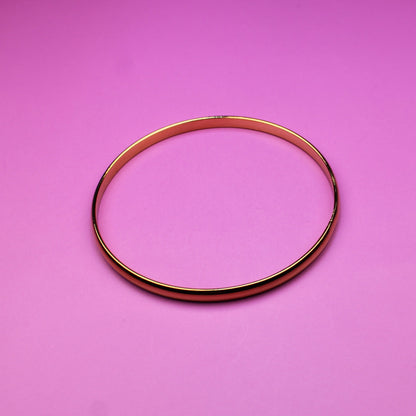 Gold bracelet on a pink background