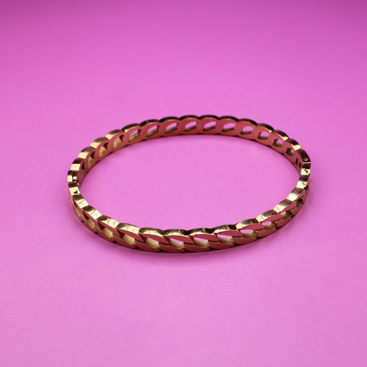 Gold bracelet on a pink background