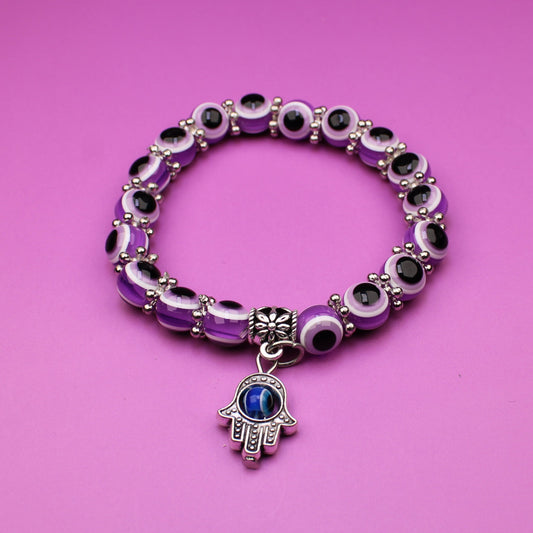 Bracelet with a hamsa charm on a pink background