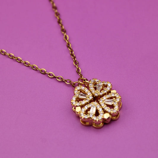 Gold necklace with a floral pendant on a purple background