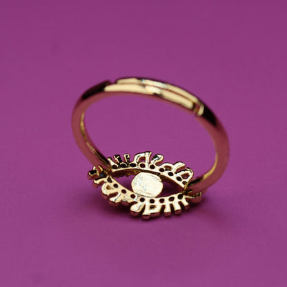 Gold ring with a decorative design on a purple background