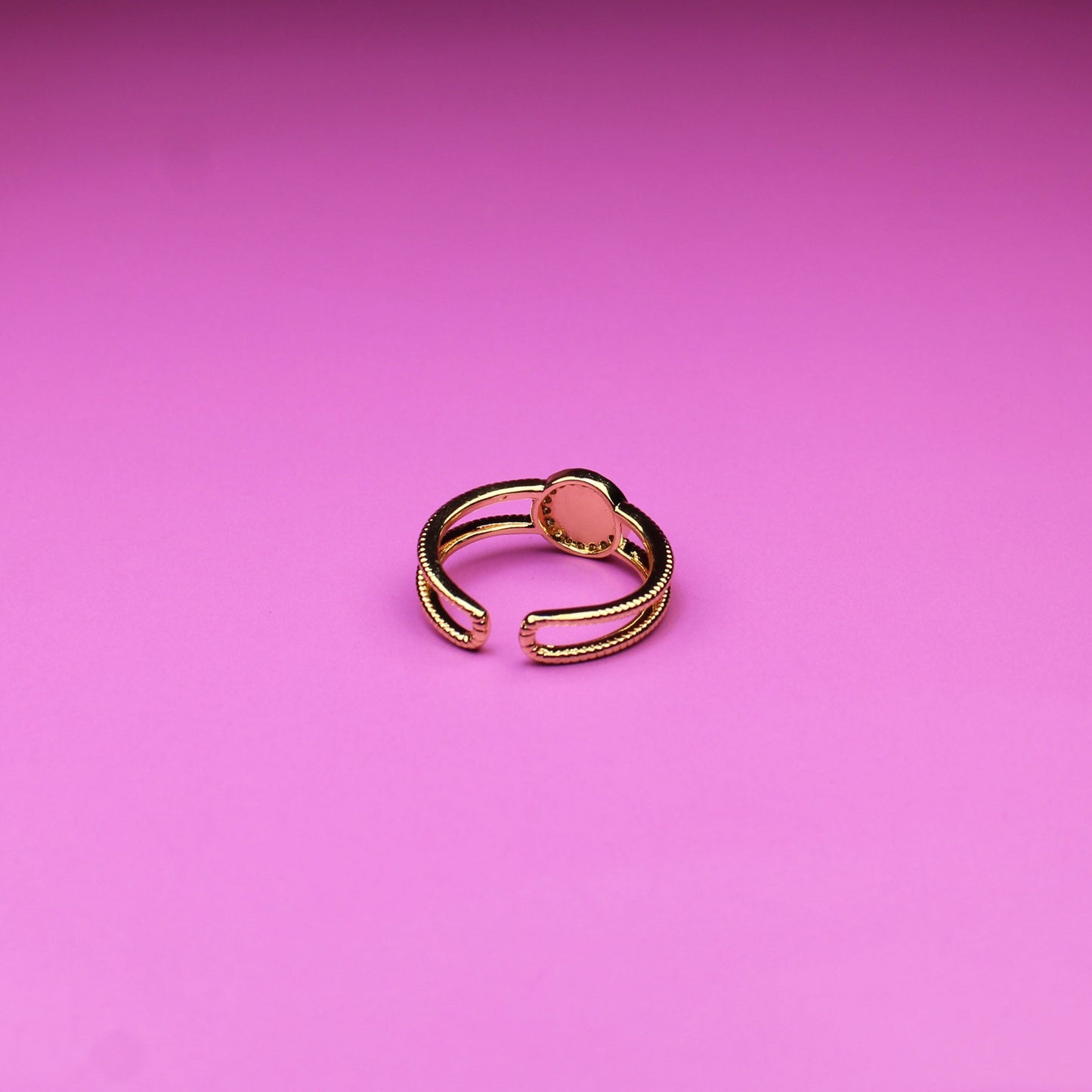 Gold ring on a pink background
