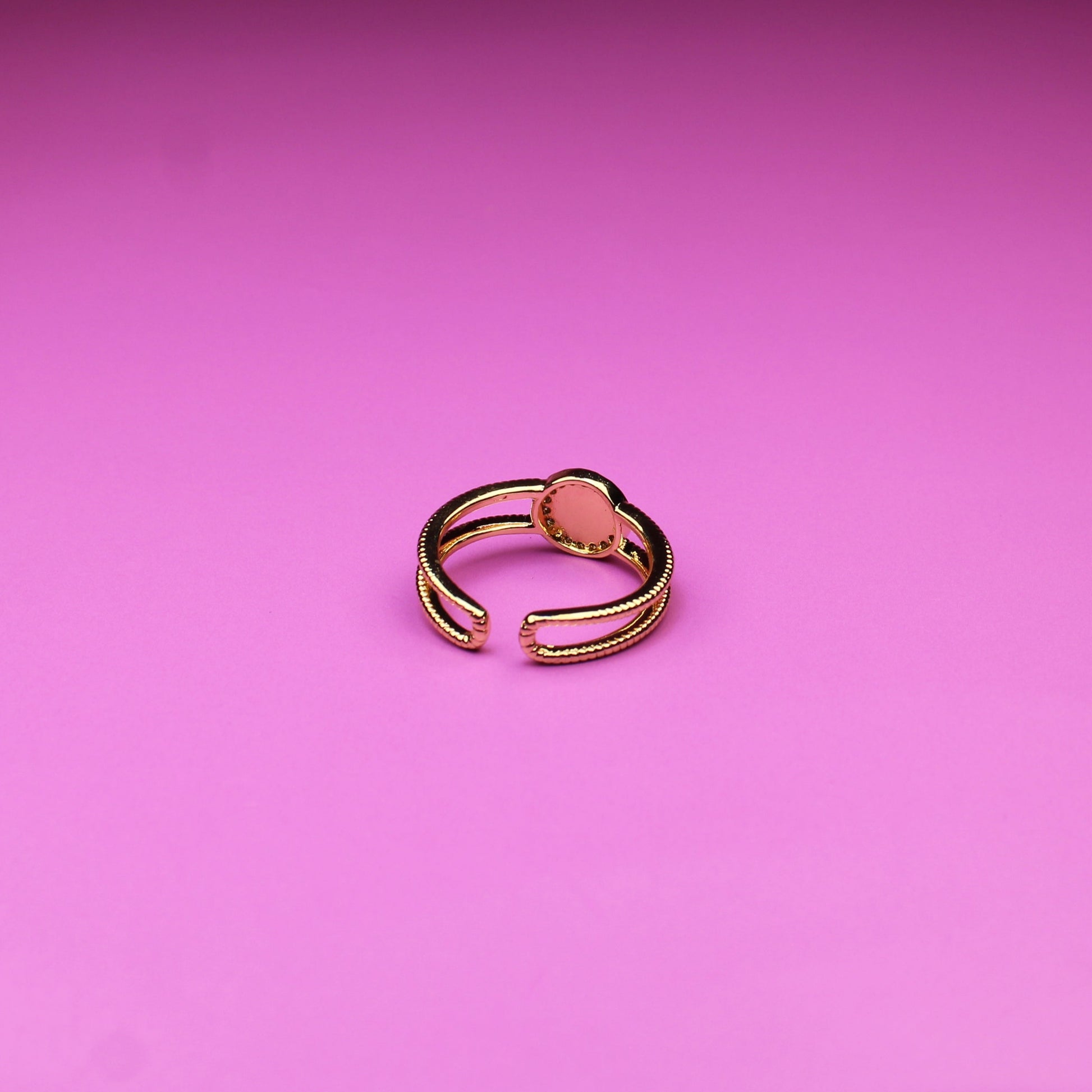 Gold ring on a pink background