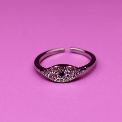 Silver ring with a black gemstone on a pink background