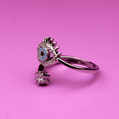 Silver ring with a blue gemstone on a pink background