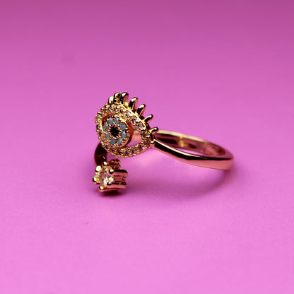 Gold ring with a heart-shaped gem on a pink background