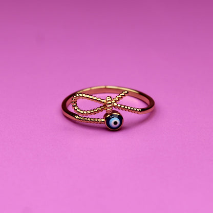 Gold ring with a blue gemstone on a pink background