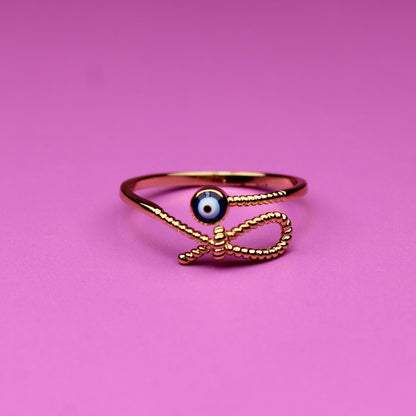 Gold ring with a black gemstone on a pink background