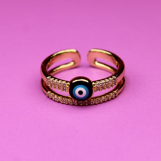 Gold ring with a blue gem on a pink background