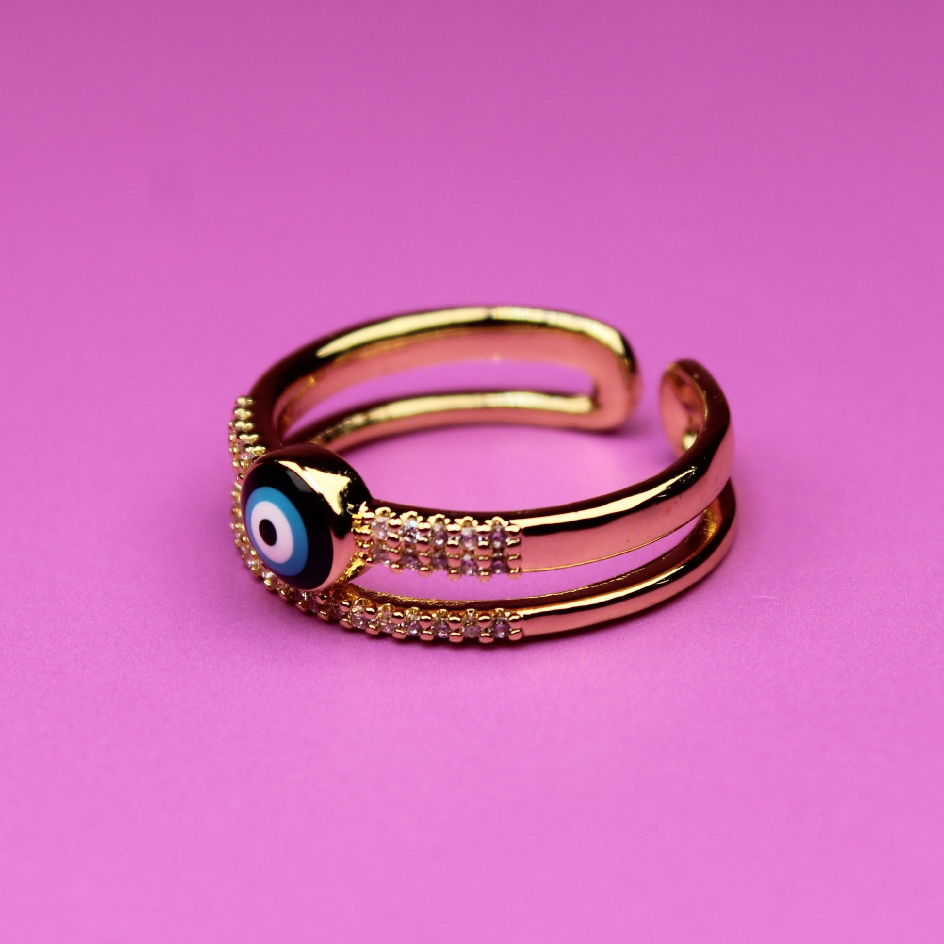 Gold ring with a blue gemstone on a pink background