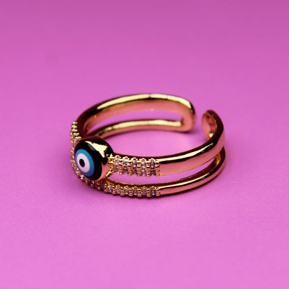 Gold ring with a blue gemstone on a pink background