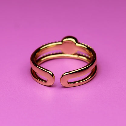 Rose gold ring on a pink background