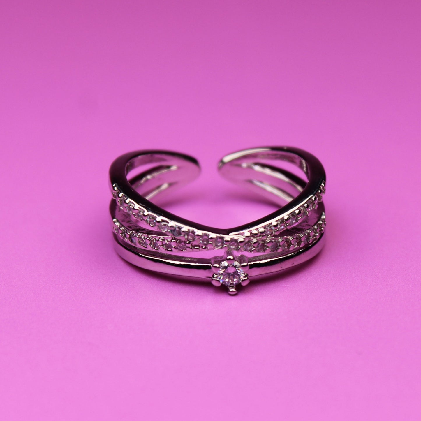 Silver ring with gemstones on a pink background