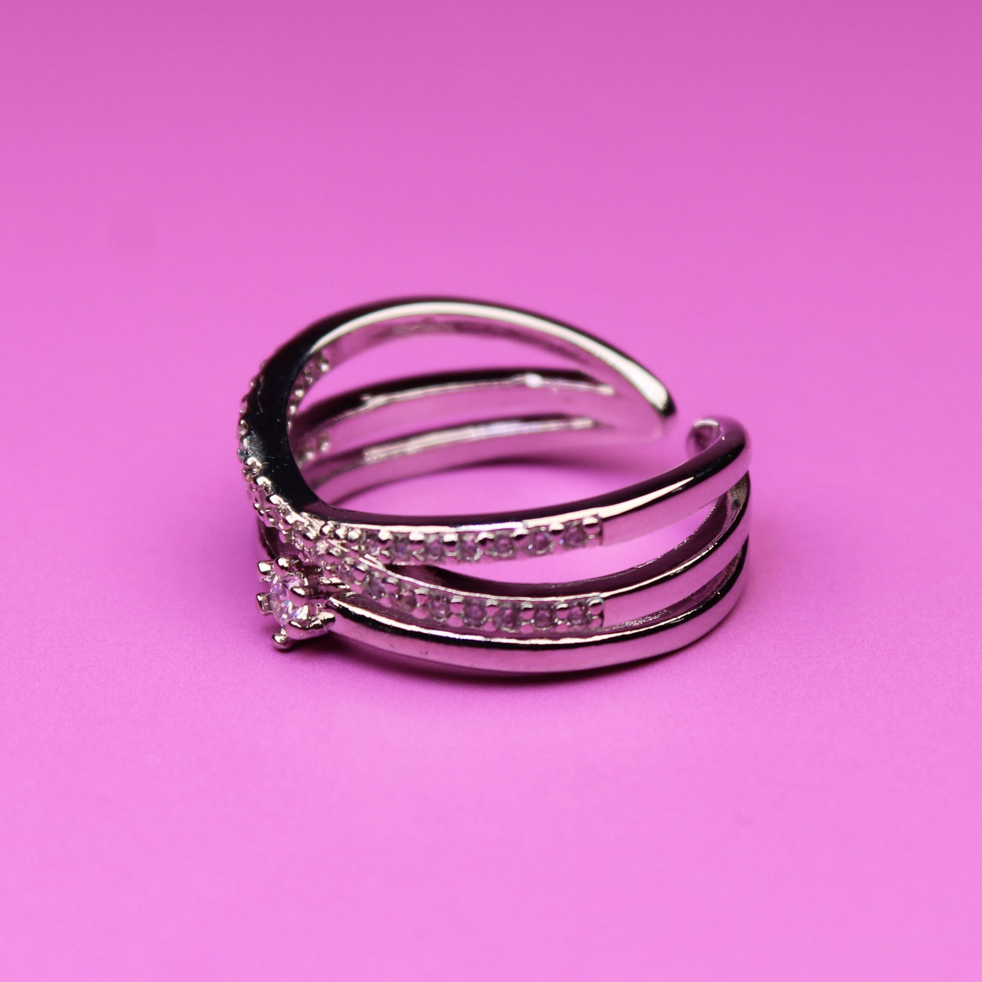 Silver ring with gemstones on a pink background