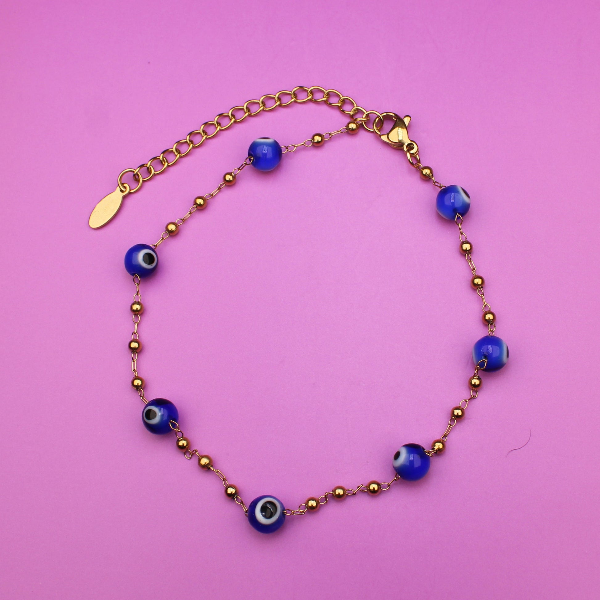 Bracelet with blue beads on a pink background