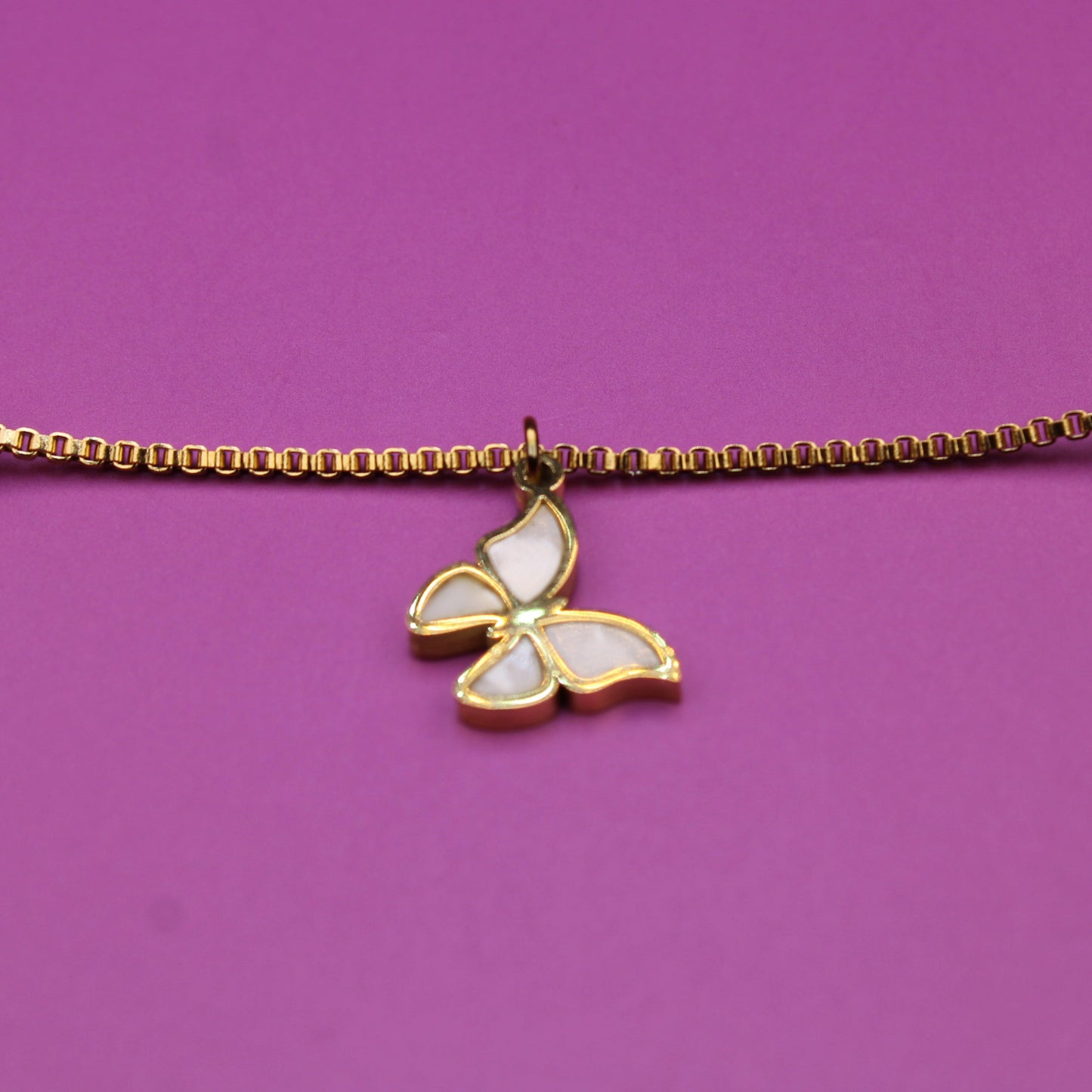 Bracelet with a butterfly charm on a purple background