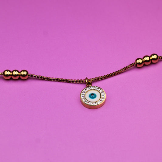 Bracelet with a small round charm on a pink background