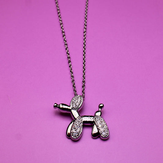 Necklace with a balloon dog pendant on a pink background