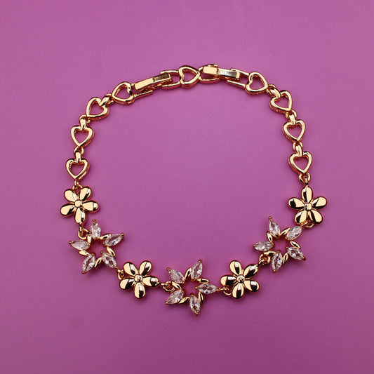 Gold bracelet with floral designs on a purple background