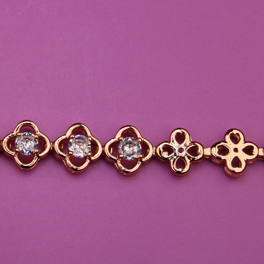 Gold bracelet with diamond accents on a purple background