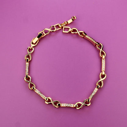 Gold chain bracelet on a pink background