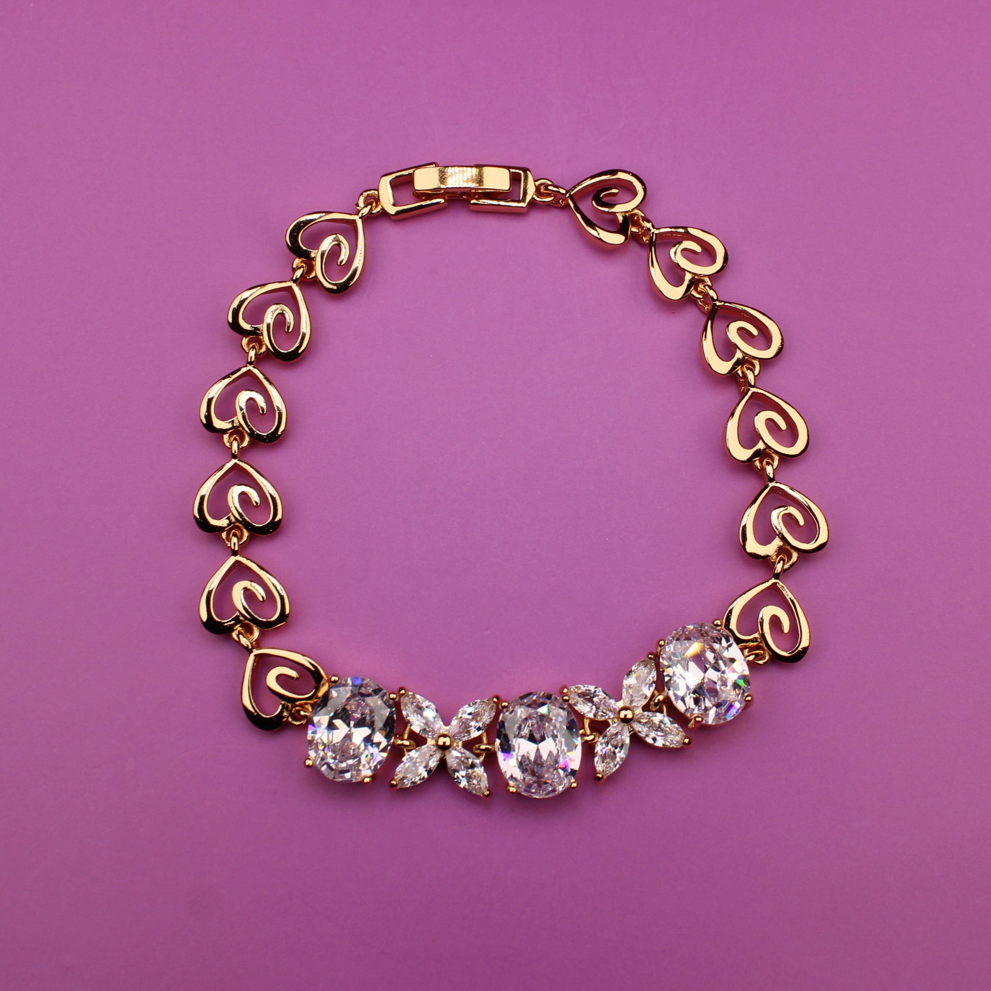 Gold bracelet with heart-shaped links on a purple background