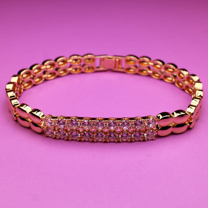 Rose gold bracelet with pink stones on a pink background