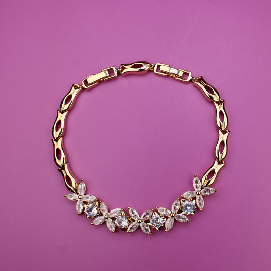 Gold necklace with floral design on a pink background