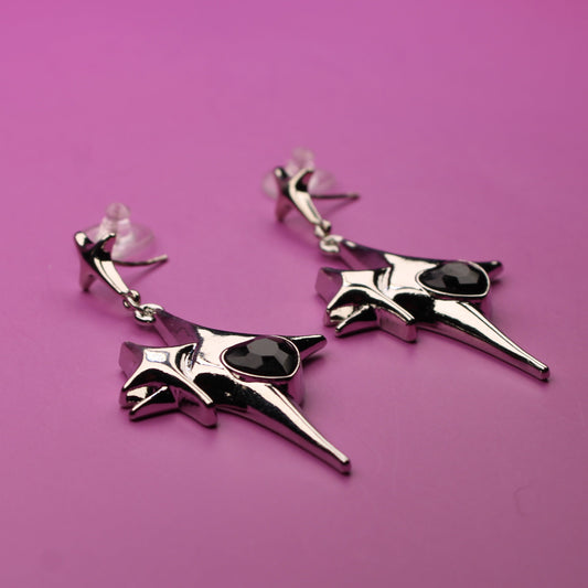 Pair of silver earrings with black stones on a pink background