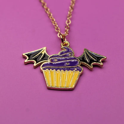 Necklace with a cupcake pendant featuring bat wings on a purple background