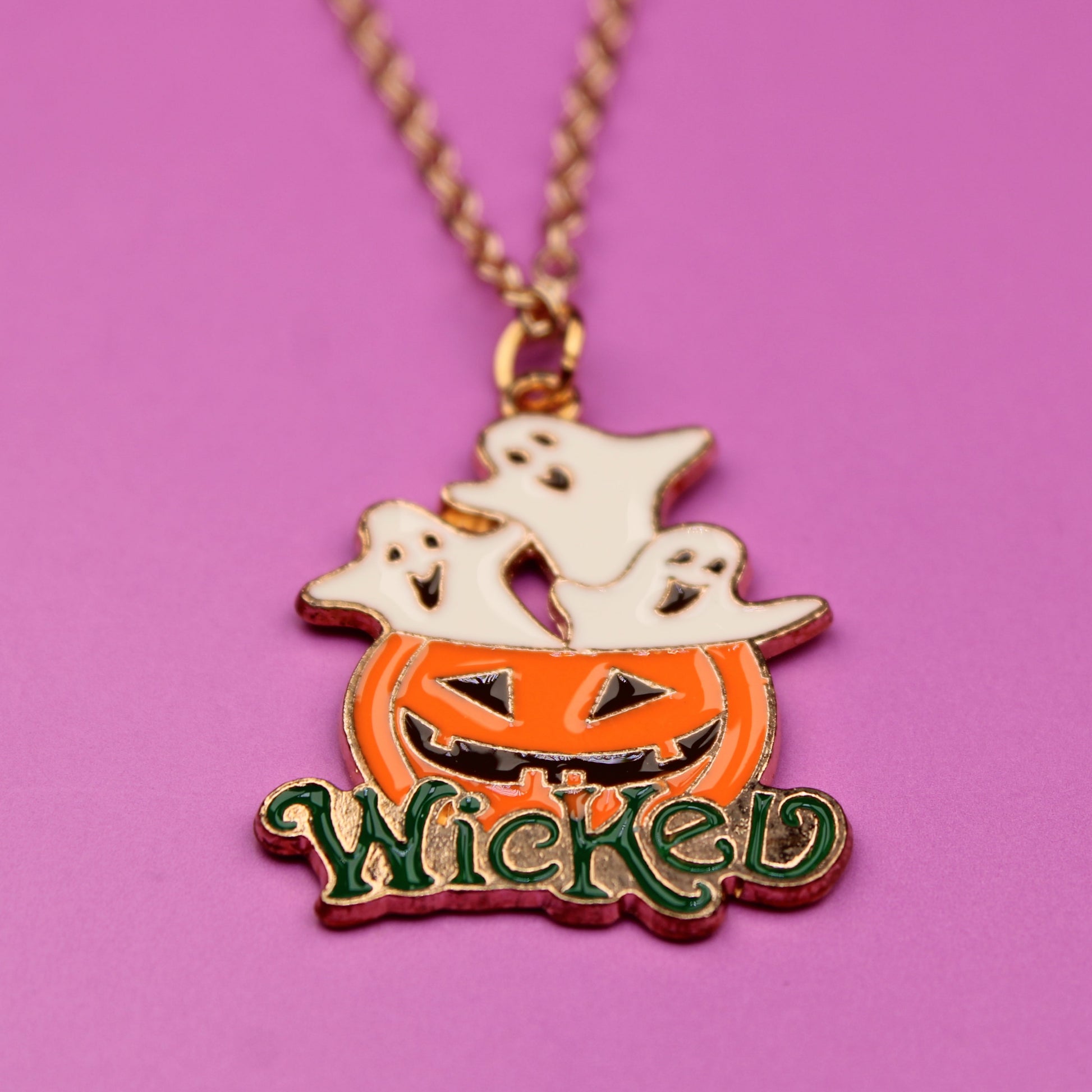 Halloween-themed necklace with pumpkin, ghost, and 'Wicked' text on a pink background