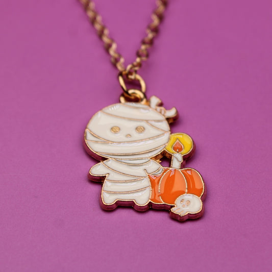 Necklace with a mummy and pumpkin pendant on a purple background