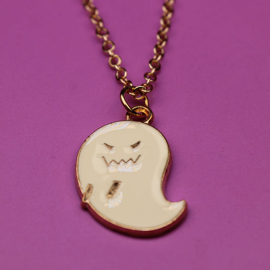 Ghost-shaped pendant on a chain against a purple background