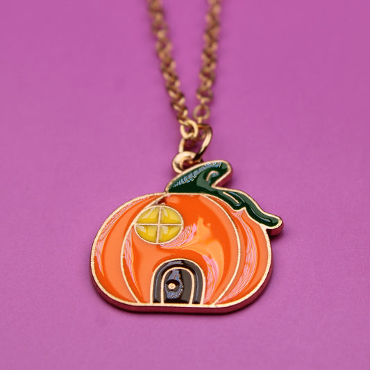 Pumpkin-shaped pendant necklace on a purple background