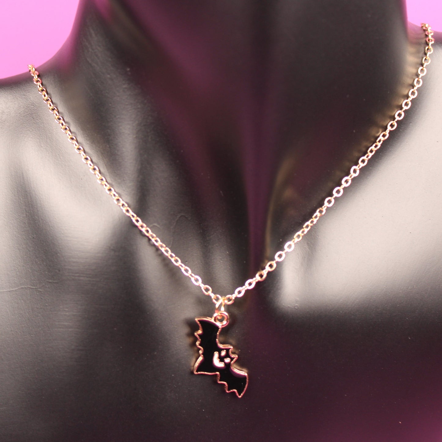 Necklace with a pendant shaped like a state on a mannequin bust against a pink background