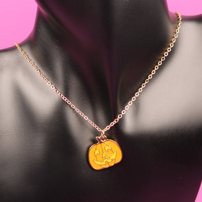 Gold necklace with a yellow pendant on a black mannequin bust against a pink background