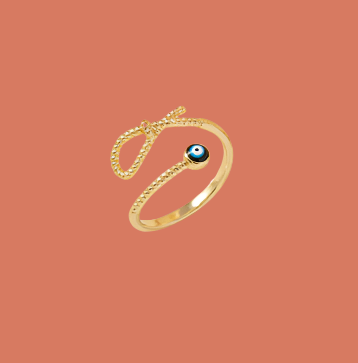 Gold ring with a blue gemstone on a white dish with a floral background