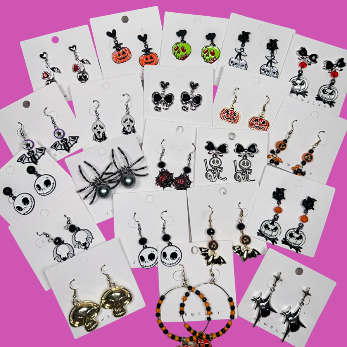 Collection of earrings on display cards against a gray background